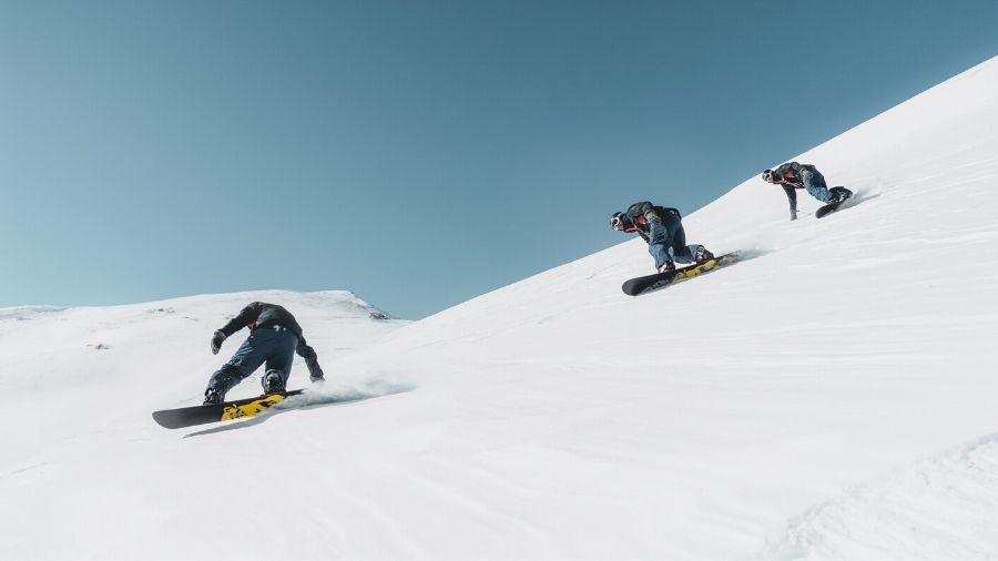 3 friends snowboarding together
