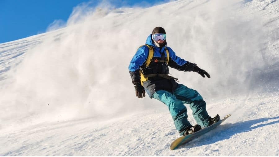 Beginner Snowboarder snowboarding down a snowy hill 